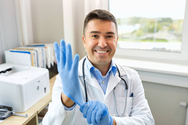 medico sorridente con guanti protettivi in clinica
 - Foto, immagini
