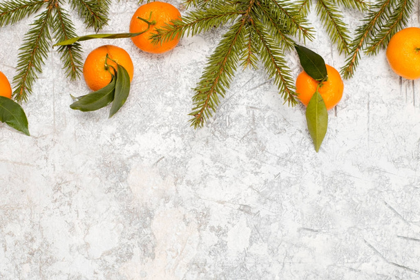 Christmas stone background with snow fir tree and tangerines. Top view with copy space - Foto, Imagen
