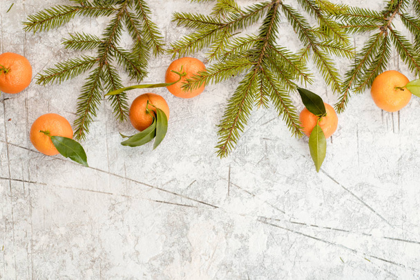 Christmas stone background with snow fir tree and tangerines. Top view with copy space - Zdjęcie, obraz