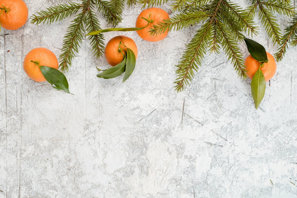 Christmas stone background with snow fir tree and tangerines. Top view with copy space - Photo, Image
