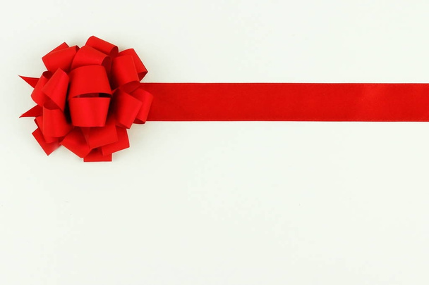 one satin red ribbon for packing gifts and decoration on a white background. Holiday concept.Copy space. top view. - Φωτογραφία, εικόνα