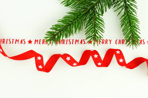 Composición navideña hecha de rama de árbol de Navidad y cintas sobre fondo blanco. Vista superior. espacio de copia. concepto de vacaciones de invierno
 - Foto, imagen