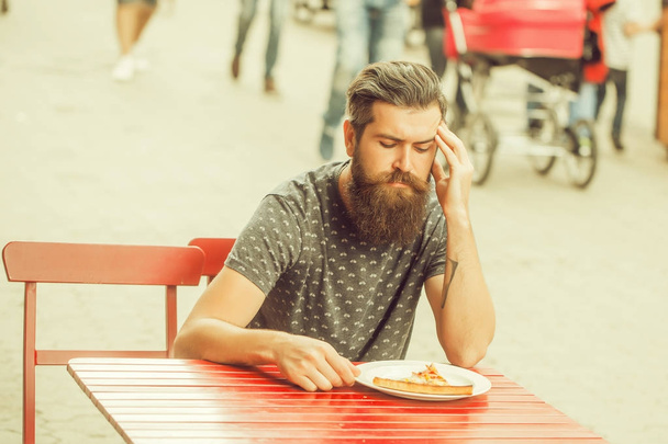 handsome bearded man with pizza in cafe - Foto, immagini
