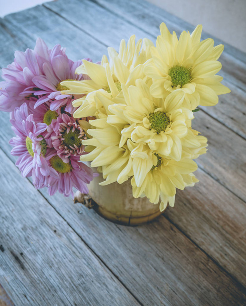 Imagem retro, flor rosa e amarela em vaso de bambu na mesa, vin
 - Foto, Imagem