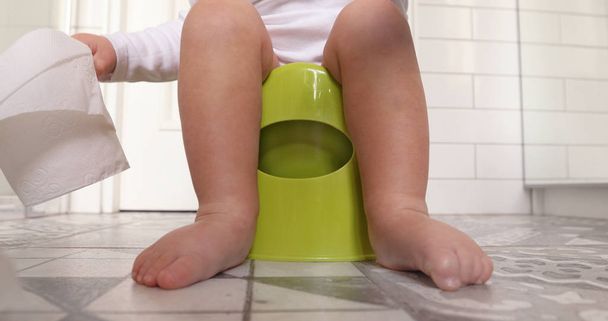 Bebé sentado chamberpot sus piernas colgando olla
 - Foto, imagen
