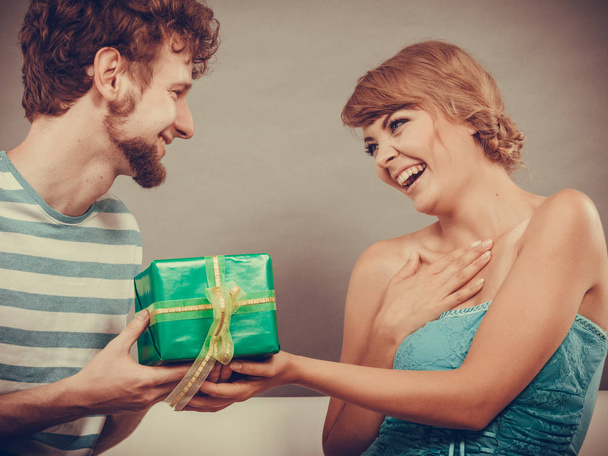 Young man giving woman gift box - Foto, afbeelding
