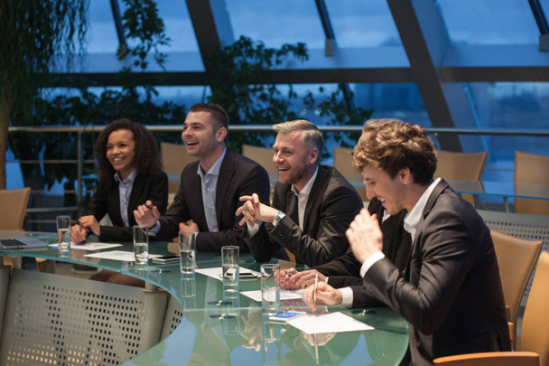 A group of business people sitting at a table discussing and laughing. - Fotoğraf, Görsel