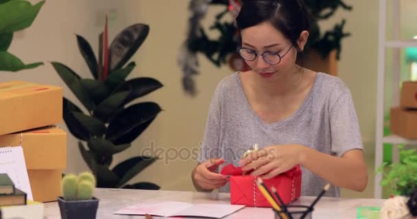 Primer plano de asiático linda chica urdimbre caja de regalo y escritura feliz tarjeta con sonrisa cara
 - Imágenes, Vídeo