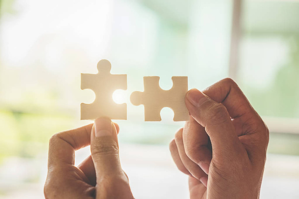 Business woman hands connecting jigsaw puzzle. Business solutions, success and strategy concept. Close up photo with selective focus. - Foto, imagen