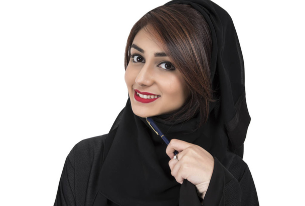 Портрет арабской молодой улыбающейся женщины, держащей ручку и думающей
 - Фото, изображение