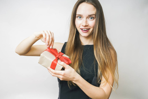 Excited woman opening gift on a white background  - Foto, Bild