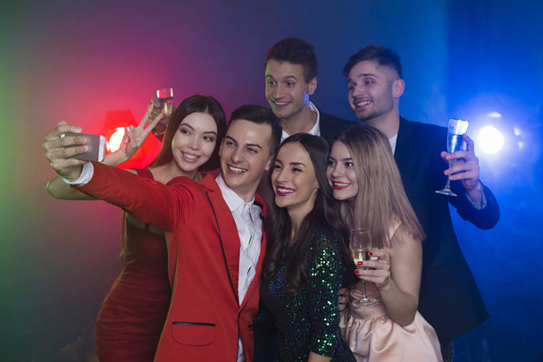 Amigos geniales. Una compañía de amigos felices en la fiesta hacen una foto selfie con champán. Año Nuevo. Cumpleaños. Navidad
. - Foto, Imagen