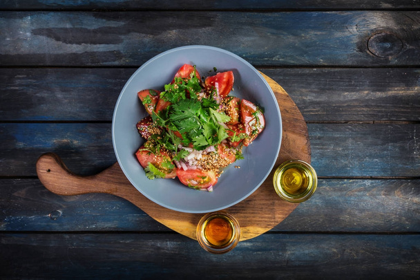 サラダ トマト玉ねぎパセリと木の板でゴマ油の 2 種類。トップ ビュー - 写真・画像