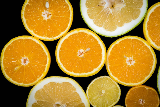 Zitrusfrüchte (Orange, Zitrone, Grapefruit, Mandarine, Limette) isoliert auf dem schwarzen Hintergrund. Obst Lebensmittel Hintergrund. Sortiment frischer Zitrusfrüchte - Foto, Bild