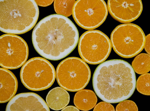 Citrus fruits (orange, lemon, grapefruit, mandarin, lime) isolated on the black background. Fruit food background. Fresh citrus fruit assortment - Photo, Image