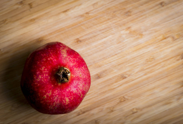 Fresh red pomegranate on the wood background, studio shot - Фото, изображение