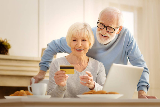 Happy couple looking at credit card - Zdjęcie, obraz