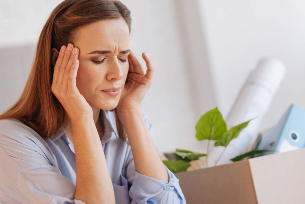 Nervous emotional woman having a headache after being dismissed - Photo, image