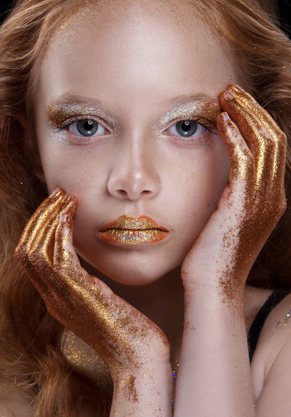 Cute redhead teenage model with bright makeup and colorful glitter and sparkles on her face and body. - Фото, изображение