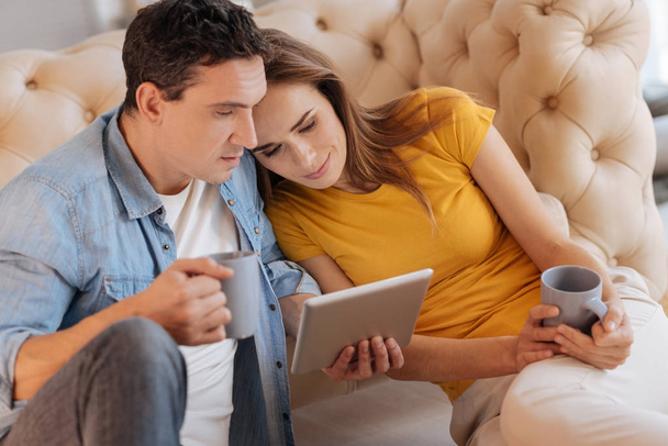 Cheerful couple watching a film while relaxing together - Foto, Imagen