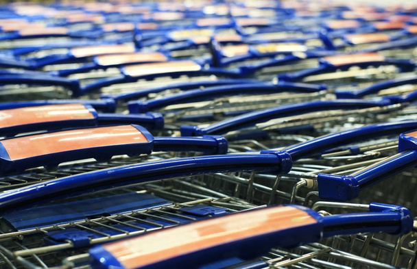 Shopping carts standing in a row in the big store - Fotó, kép