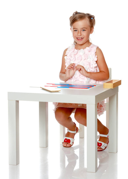 A little girl is studying Montessori stuff. - 写真・画像
