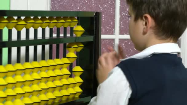 Iskola fiú öltözött, mint tanár tartja abacus, egy osztályteremben. - Felvétel, videó