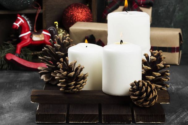 Burning candles and Christmas attributes on a dark background - Valokuva, kuva