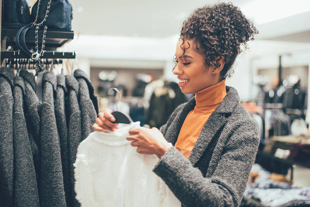 Μαύρη νεαρή γυναίκα να κάνει ψώνια σε ένα κατάστημα - Φωτογραφία, εικόνα
