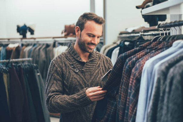junger blonder Mann beim Einkaufen in einem Geschäft - Foto, Bild