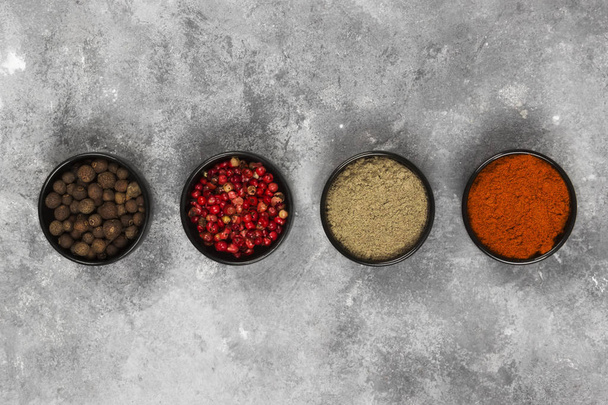 Various pepper on a gray background. Top view - Foto, imagen