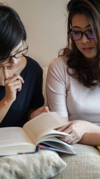 Two Asian woman friends reading books and discussion on hobby - Φωτογραφία, εικόνα
