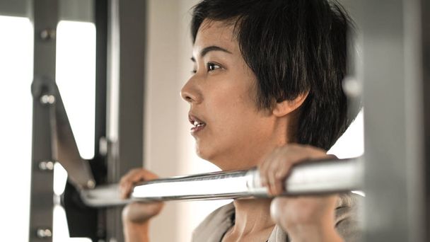 Asian short hair woman fitness training machine smile face - Foto, immagini