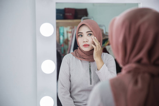  woman with hijab looking at her face  - Foto, immagini