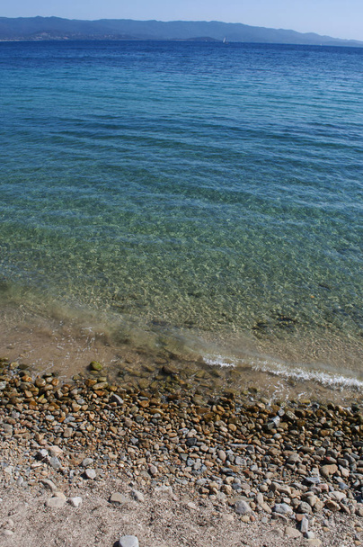 Corsica, 01/09/2017: crystal clear water of the Mediterranean Sea at the urban beach of Ajaccio, famous city on the west coast of the southern Corsica with view of the coastline - Photo, Image