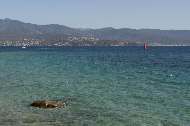 Corsica, 01 / 09 / 2017: acque cristalline del Mar Mediterraneo sulla spiaggia urbana di Ajaccio, famosa città sulla costa occidentale della Corsica meridionale con vista sulla costa
 - Foto, immagini