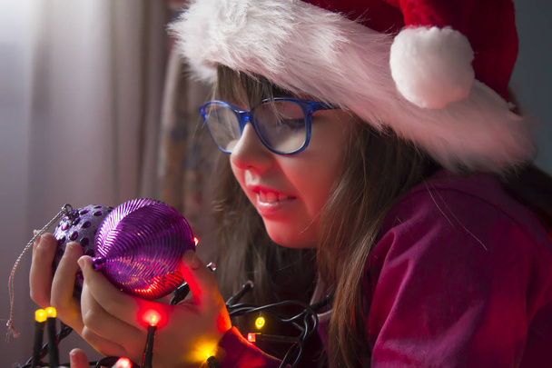 little girl with santa hat and christmas lights - Φωτογραφία, εικόνα
