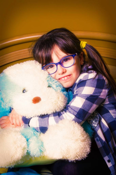 Portret van een meisje met pigtails met teddybeer - Foto, afbeelding