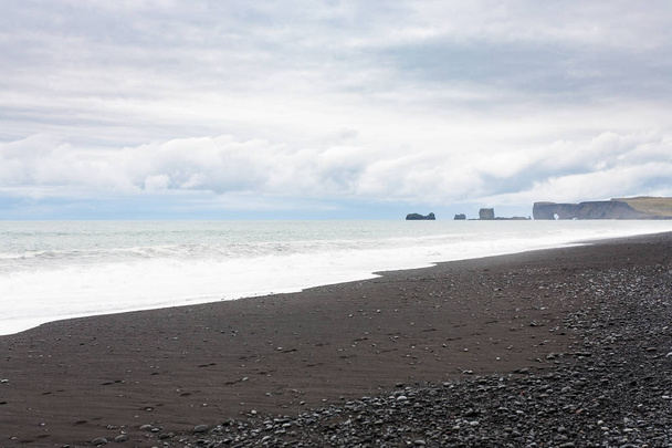 Playa de Reynisfjara y vista de las rocas Dyrholaey
 - Foto, imagen