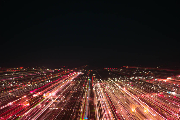 lichte lijnen met lange blootstelling, snelheid beweging abstracte achtergrond in de donkere nacht, blast zoom effect, zoom uitbarsting van licht in de stad - Foto, afbeelding