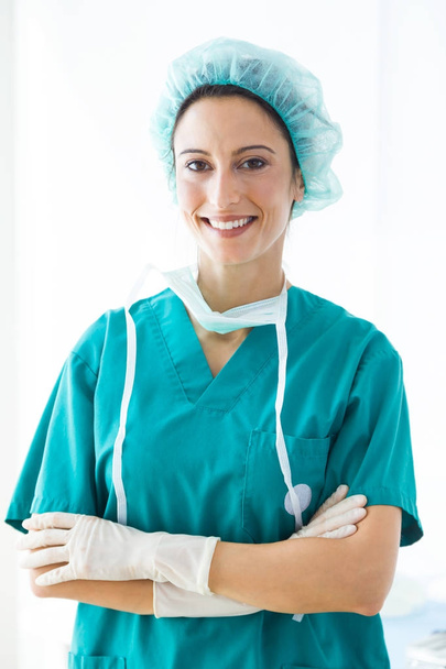 Confident female medical worker wearing hat and mask looking to the camera. - Foto, Imagen