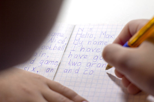 Yakın çekim çocuk el ile İngilizce kelime el ile geleneksel beyaz not defteri kağıda yazı kalem. - Fotoğraf, Görsel