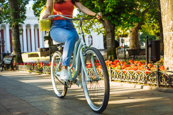 Closeup of young beautiful woman riding vintage bicycle in summer park. Green trees background     - Foto, afbeelding