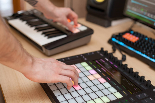 Producent maakt een muziek op professionele productie controller met drukknop pads - Foto, afbeelding
