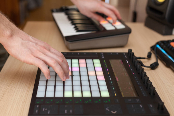 Producer makes a music on professional production controller with push button pads - 写真・画像