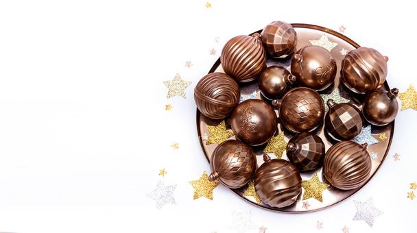 Bolas de chocolate dorado de Navidad sobre un fondo blanco
 - Foto, Imagen