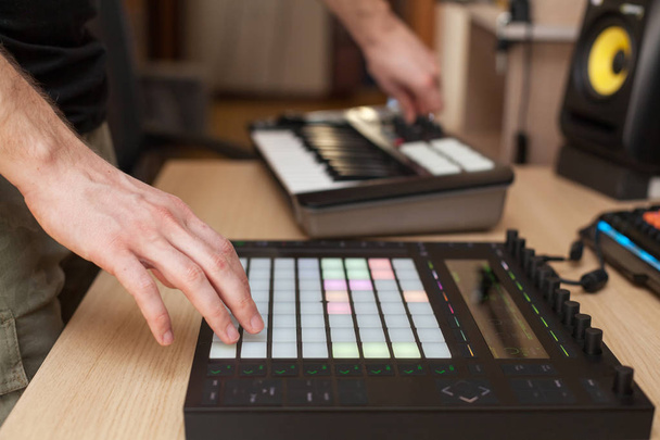 Producer makes a music on professional production controller with push button pads - Foto, Bild