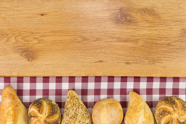 Fresh bread on wooden table background. - Foto, afbeelding