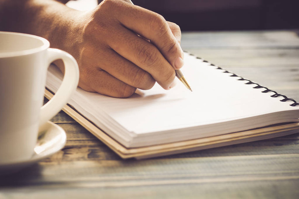 Schrijven van zuivel op notebook in koffiehuis, concept als herinnering aan het leven en onderwijs - Foto, afbeelding