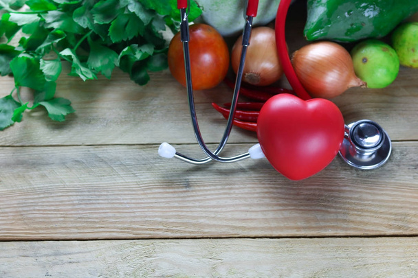 Sağlıklı kalp kavramı, kulak doktorun ot yaprağı ve vetgetable ahşap arka plan üzerinde - Fotoğraf, Görsel